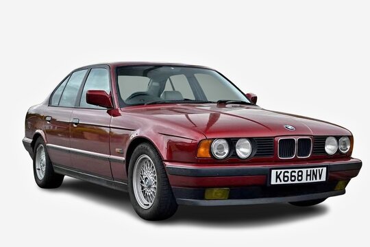 Classic BMW E34 sedan posing in studio with white background