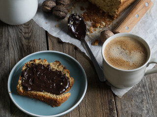 Artisanal and slow breakfast on a wooden table with natural side light. Banana bread with...