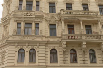 Fototapeta premium The ornate facade of this impressive building features intricate architectural details and multiple beautifully arranged windows, all in a rich historical style that captivates passersby