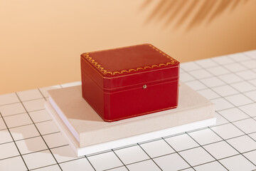 Elegant Red and Gold Gift Box on Books: Modern Luxury Present for Special Occasions on Grid Background