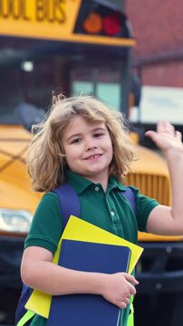 School kid waving hand near school bus. Child go to school bus. American education scene. School moment. USA childhood memory. Learning today. Child with sook and backpack ready to lesson.