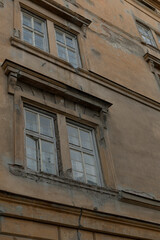 Obraz premium A closeup view of worn and weathered windows on an old building facade, highlighting the intricate architectural details that tell a story of time and history within the structure