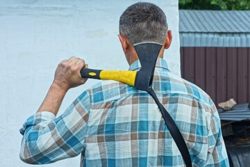 one iron black industrial sharp dangerous with yellow plastic handle small hatchet in hand on...