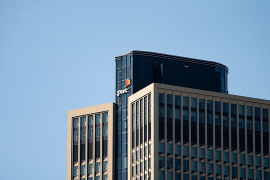 FRANKFURT, GERMANY - 14. May 2025: Tower 185 with the PwC (PricewaterhouseCoopers) logo sign on the facade. The skyscraper is located in Frankfurt Gallus. Detail of the top of the building.