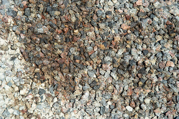 Close-up view captures a mixture of gravel stones displaying a range of colors and sizes under...
