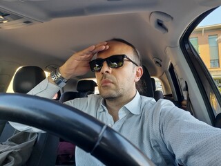 Uomo alla guida dell'automobile per le strade della città
