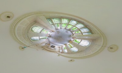 Tiny planet effect showing circular ceiling with arched windows in dilapidated Sanatorium Metallurgist, an old SPA of 1980s ussr, with trees growing inside, located in Georgia