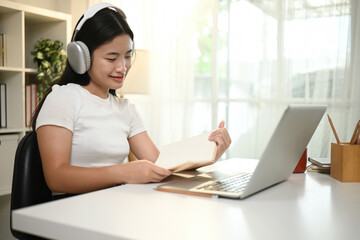 Close-up image of A Happy Asian High School Student Studying with a Laptop and a Notebook, Engaged in Online Learning
