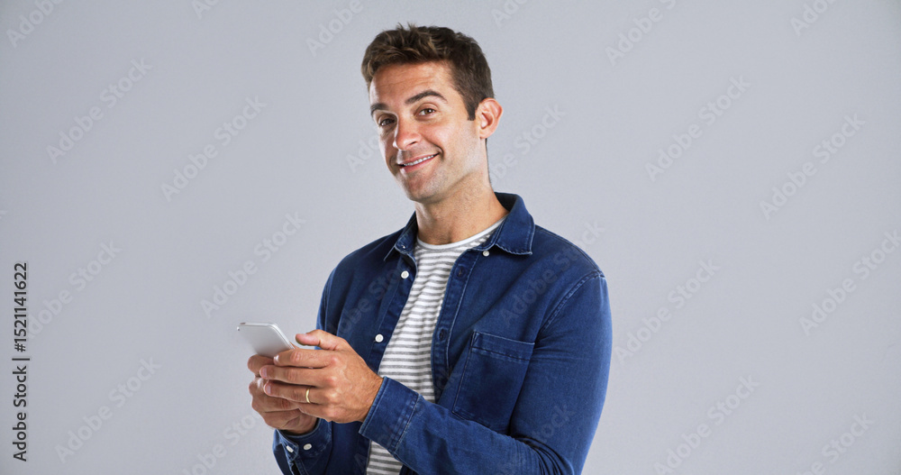 Poster Portrait, happy man and typing with mobile in studio for social media or text on white background. Phone, smile and person with message on app for download, network and blog post with mockup space