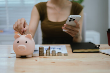 Woman putting money in piggy bank, money saving concept
