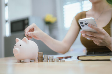 Woman putting money in piggy bank, money saving concept
