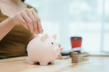 Woman putting money in piggy bank, money saving concept
