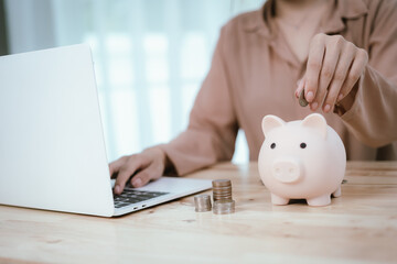 Woman putting money in piggy bank, money saving concept
