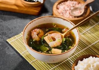 Miso soup with shrimp in natural daylight, vibrant color, modern Japanese food restaurant presentation