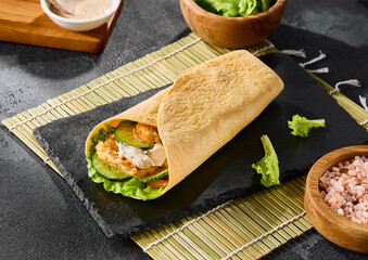 Caesar roll in tortilla on slate, bright natural light, minimalistic composition, fresh and appetizing