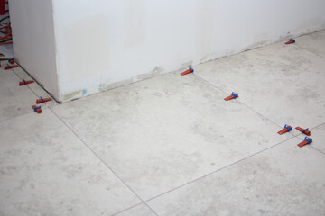 Close-up of ceramic tile installation with tile clips and spacers for grouting
