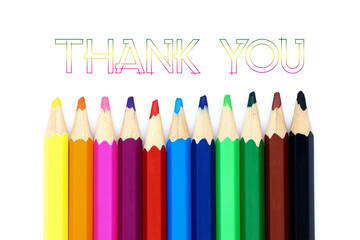 Fototapeta premium Colored pencils in a row isolated on a white background. Thank you card. End of school year concept.