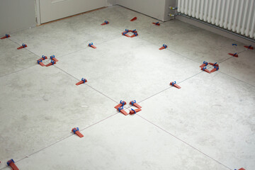 Close-up of ceramic tile installation with tile clips and spacers for grouting