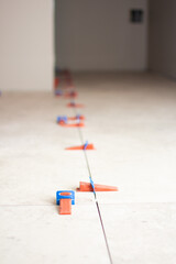 Close-up of ceramic tile installation with tile clips and spacers for grouting
