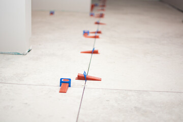 Close-up of ceramic tile installation with tile clips and spacers for grouting