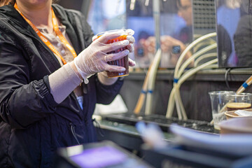 transparent plastic cup of recyclable materials chilled drink beer or kvass in gloves. street food
