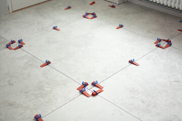 Close-up of ceramic tile installation with tile clips and spacers for grouting