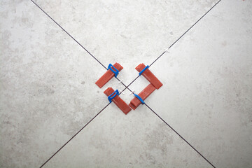 Close-up of ceramic tile installation with tile clips and spacers for grouting