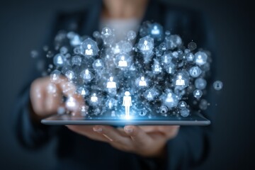 Digital networking concept with glowing icons and figures emerging from a tablet held by a person in a dark setting