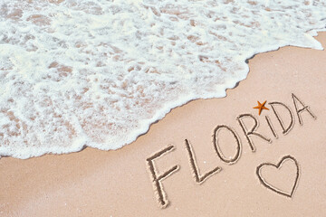 Foamy ocean waves washing over golden sand with sea stars and 