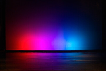 Empty stage illuminated with red and blue light reflecting on the floor