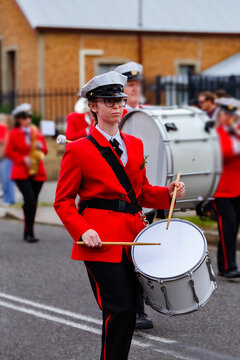 Young female drummer playing in local band during ANZAC day parade march