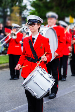 Young female drummer playing in local band during ANZAC day parade march