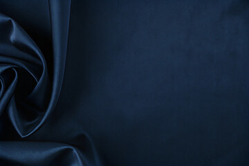 Luxurious deep navy blue satin fabric with draped rose pattern.