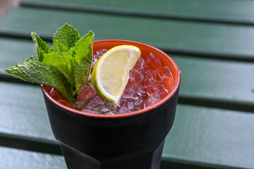 glass of mohito coctail with crushed ice, lime and mint