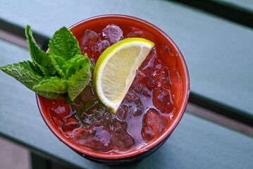 glass of mohito coctail with crushed ice, lime and mint
