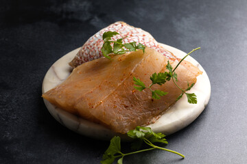 Whole raw red snapper fish on a cutting board.