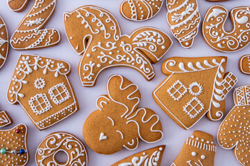 Gingerbread decorated with white sugar glaze. Food background. Christmas tree cookies. Houses different shape. Home banking
