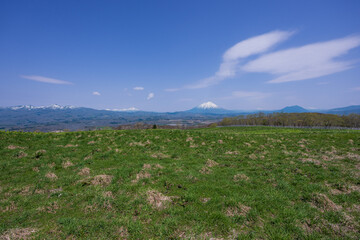 牧場から見渡す残雪のニセコ連峰や羊蹄山のパノラマ風景