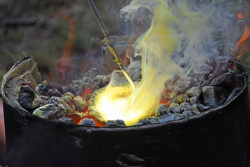 weißglühender, rauchender Schmelztiegel in Ofen mit Kohlefeuer