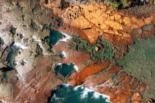 Aerial view of a rugged, rocky shoreline with tide pools