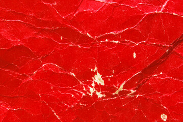 A sheet of worn red glossy paper texture as background