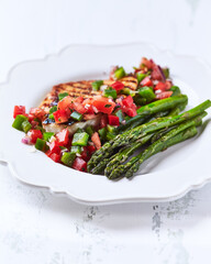 Grilled chicken fillet with asparagus and tomato salsa. Close up. 