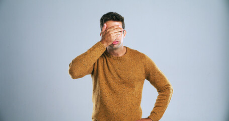 Frustrated, upset and man with hand on face in studio for mistake, disappointment or fail. Stress,...
