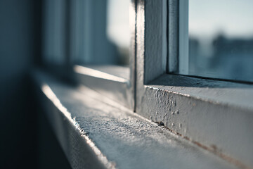 White painted wooden window sill with peeling paint and weathered surface