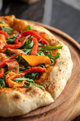 Closeup on gourmet appetizing italian pizza with salmon and baked pepper