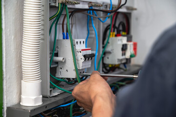 Close up electrician installing combiner box in house