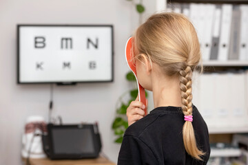 Vision Problem in Children.  Kids eye testing. Child Looking on Vision Board. Vision Screening in...