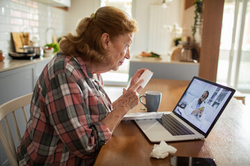 Senior woman in video call with doctor for advice at home