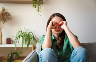 Upset woman crying and rubbing her eyes with her fists.