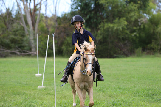 Young equestrian rider on a light-coloured horse